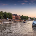 Bootstour Heidelberg: hier liegen Schiffe der Weißen Flotte vor dem Neckarufer und eines ist auf dem Neckar unterwegs. Die Touren sind für verschiedene Anlässe sehr beliebt.