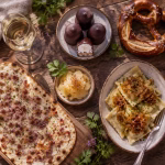 Kulinarische Stadtführung Heidelberg: Flammkuchen, Handkäse, Maultaschen und regionale Weine auf einem rustikalen Holztisch in der Altstadt