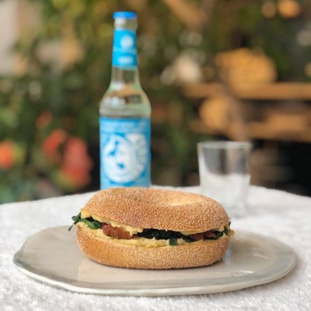 all vegan bagel for brunch with hummus, spinage, pine nuts, dried tomatoes and a sense of olive oil heidelber rohrbach